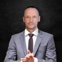 Happy business man wearing grey suit standing and folding arms